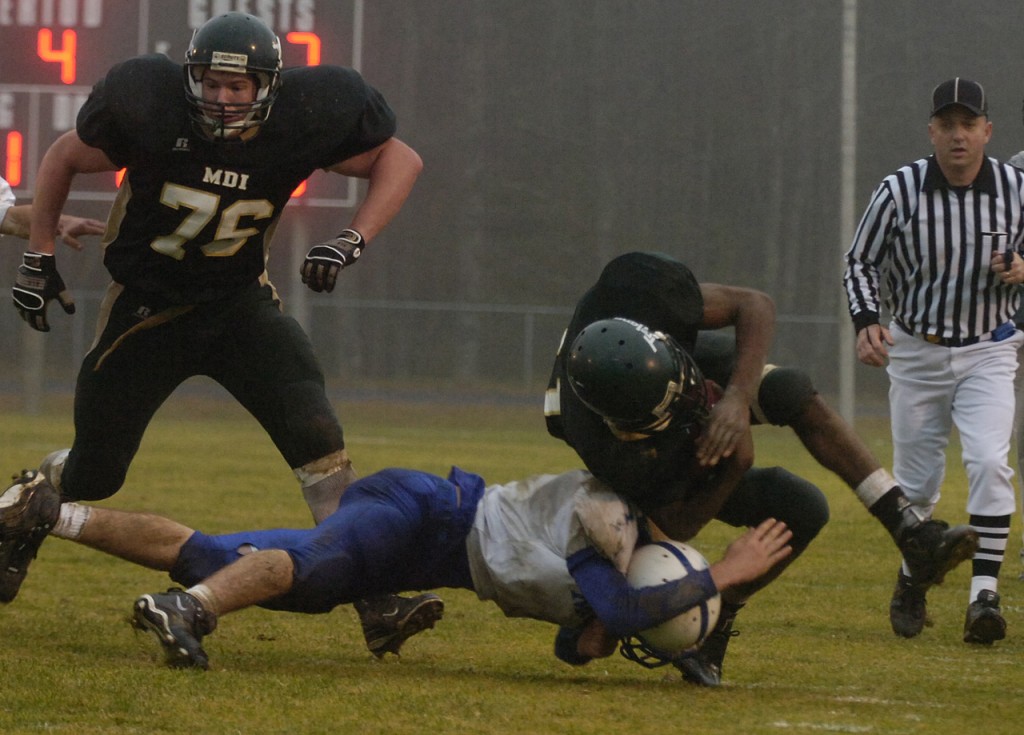 Mt. Desert Island wide receiver Terrance Jones, right, gets his legs taken out from under him by Morse's Randall Rytky during 4th period action at MDI on Saturday. Morse won 10-7. Mt. Desert Island wide receiver Terrance Jones, right, gets his legs taken out from under him by Morse's Randall Rytky during 4th period action at MDI on Saturday. Morse won 10-7.