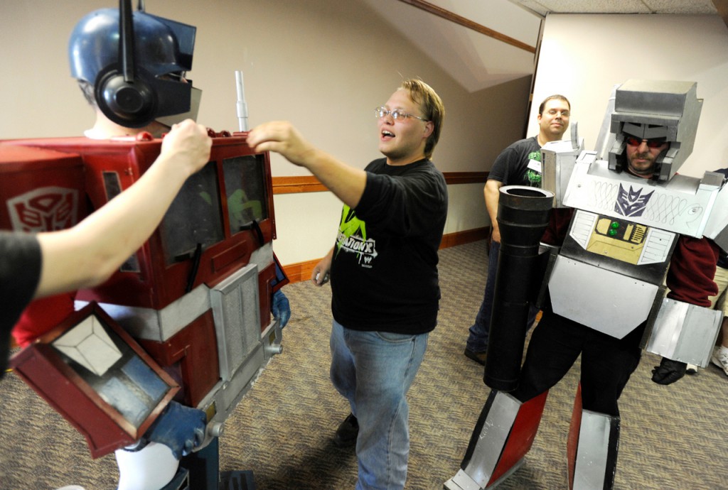 Henry Dow (center) helps make sure Optimus Prime (a Transformer character played by Ray Maddocks of Morrill) looks his best at the BangPop Comic Book and Pop Culture Convention on Saturday at the Bangor Civic Center. Behind them are Rich Nielsen of Searsport and Elmer Nickerson (far right) of Searsport, who is costumed as Megatron, another Transformer character, replete with a fusion cannon. Buy Photo Henry Dow (center) helps make sure Optimus Prime (a Transformer character played by Ray Maddocks of Morrill) looks his best at the BangPop Comic Book and Pop Culture Convention on Saturday at the Bangor Civic Center. Behind them are Rich Nielsen of Searsport and Elmer Nickerson (far right) of Searsport, who is costumed as Megatron, another Transformer character, replete with a fusion cannon. Buy Photo