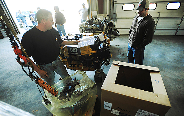 Billings Diesel and Marine mechanic Troy Morey, left, unpacks the marine gear from a crate as lobster fisherman Jason Witham, right, watches at the company's Stonington facility on Thursday, September 24, 2009. Witham's boat, Siren, is having the older 2-cycle engine replaced with a new 4-cycle, Cat C-9 diesel engine as part of the Maine Department of Enviromental Protection's, Repower Program. Witham's old engine can be seen on the floor in the background. (Bangor Daily News/Kevin Bennett) Billings Diesel and Marine mechanic Troy Morey, left, unpacks the marine gear from a crate as lobster fisherman Jason Witham, right, watches at the company's Stonington facility on Thursday, September 24, 2009. Witham's boat, Siren, is having the older 2-cycle engine replaced with a new 4-cycle, Cat C-9 diesel engine as part of the Maine Department of Enviromental Protection's, Repower Program. Witham's old engine can be seen on the floor in the background. (Bangor Daily News/Kevin Bennett)
