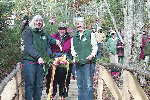 Arizona resident Janet Stetser (center) cuts the branch and ribbon during Saturday's dedication of the 150 acre Stetser Preserve on the Sheepscot River Watershed in Jefferson. Stetser made a vow to preserve the land when she bought the parcels more than 40 years ago. With Stetser are Maureen Hoffman, executive director of the Sheepscot Valley Conservation Association (left) and SVCA president Honor Sage (right). (BANGOR DAILY NEWS PHOTO BY WALTER GRIFFIN) Arizona resident Janet Stetser (center) cuts the branch and ribbon during Saturday's dedication of the 150 acre Stetser Preserve on the Sheepscot River Watershed in Jefferson. Stetser made a vow to preserve the land when she bought the parcels more than 40 years ago. With Stetser are Maureen Hoffman, executive director of the Sheepscot Valley Conservation Association (left) and SVCA president Honor Sage (right). (BANGOR DAILY NEWS PHOTO BY WALTER GRIFFIN)