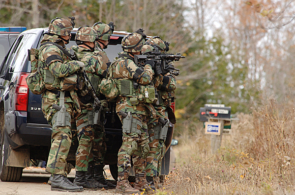 Members of the state police tactical team wait on the Pratt Road in Newport as other officers search a property and building on the Pratt Road in Newport, as a massive manhunt continued through the day Tuesday, Oct. 27, 2009 for Perley Goodrich, Jr., who allegedly shot and killed his father on the Rutland Road in Newport Monday night. (Bangor Daily News photo by Scott Haskell)