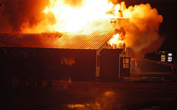 The crowd on West Broadway is silhouetted on Thursday night by the flames that roar through the Lincoln News Print Services Building. Witnesses said the fire appeared to begin in the rear of the building and spread rapidly forward. (Bangor Daily News/Nick Sambides Jr.) The crowd on West Broadway is silhouetted on Thursday night by the flames that roar through the Lincoln News Print Services Building. Witnesses said the fire appeared to begin in the rear of the building and spread rapidly forward. (Bangor Daily News/Nick Sambides Jr.)