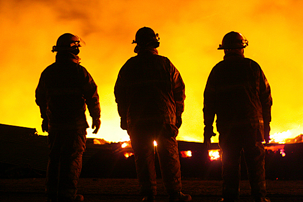 Three Fire Fighters take a breather while the Belfast Chicken barn blazes in front of them. PHOTO BY KRATKA PHOTOGRAPHY Three Fire Fighters take a breather while the Belfast Chicken barn blazes in front of them. PHOTO BY KRATKA PHOTOGRAPHY