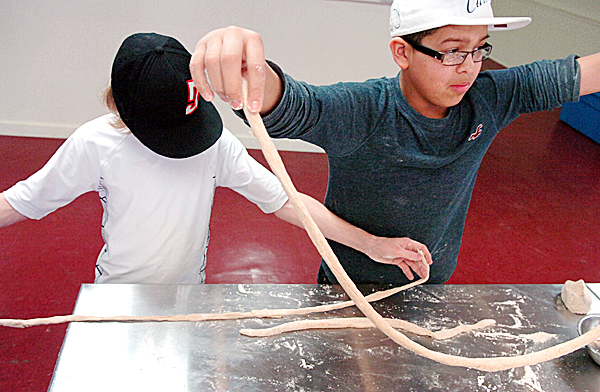 Jared Keller, 13, of Veazie (left) and Jordan Ayer, 13, of Bangor roll out dough to make pretzels Monday, Feb. 15, 2010 during a home-cooking class at The Dinner Store in Brewer. The program, called "Kids in the Kitchen - Basics to Build On", is going on this week to coincide with school vacations and is designed to introduce children to the art of cooking from scratch. (Bangor Daily News/Bridget Brown) Jared Keller, 13, of Veazie (left) and Jordan Ayer, 13, of Bangor roll out dough to make pretzels Monday, Feb. 15, 2010 during a home-cooking class at The Dinner Store in Brewer. The program, called "Kids in the Kitchen - Basics to Build On", is going on this week to coincide with school vacations and is designed to introduce children to the art of cooking from scratch. (Bangor Daily News/Bridget Brown)