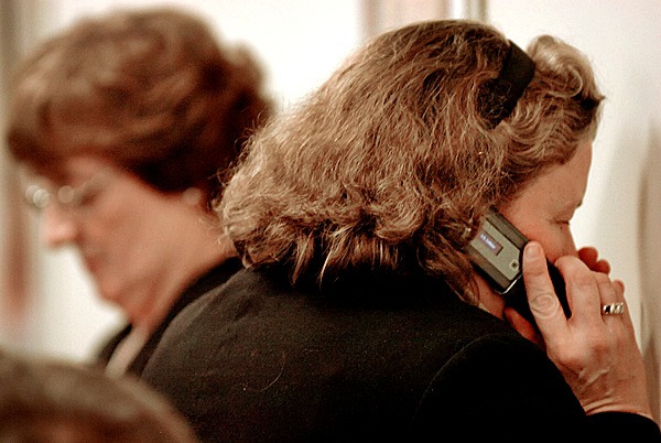 Dr. Dora Anne Mills (right), director of the Maine Center for Disease Control and Prevention, talks on her cell phone prior to testifying in opposition to Rep. Andrea Boland's bill LD 1706, An Act To Create the Children's Wireless Protection Act, during a public hearing at the State House in Augusta on Tuesday, March 2, 2010. BANGOR DAILY NEWS PHOTO BY BRIDGET BROWN Dr. Dora Anne Mills (right), director of the Maine Center for Disease Control and Prevention, talks on her cell phone prior to testifying in opposition to Rep. Andrea Boland's bill LD 1706, An Act To Create the Children's Wireless Protection Act, during a public hearing at the State House in Augusta on Tuesday, March 2, 2010. BANGOR DAILY NEWS PHOTO BY BRIDGET BROWN