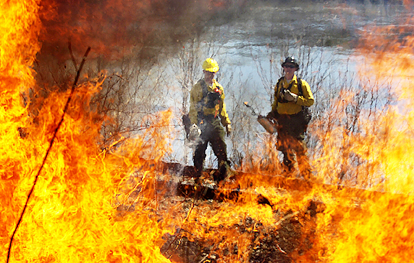Rangers with the Maine Forest Service watch flames from the fires they set during a prescribed burn along the railroad tracks on outer State Street in Bangor on Tuesday, April 13, 2010. The preventative burn was done to eliminate dry fuel that might be ignited by a passing train. (Bangor Daily News photo by Kevin Bennett) CLICK IT TO SEE A VIDEO OF THE PRESCRIBED BURN Rangers with the Maine Forest Service watch flames from the fires they set during a prescribed burn along the railroad tracks on outer State Street in Bangor on Tuesday, April 13, 2010. The preventative burn was done to eliminate dry fuel that might be ignited by a passing train. (Bangor Daily News photo by Kevin Bennett) CLICK IT TO SEE A VIDEO OF THE PRESCRIBED BURN