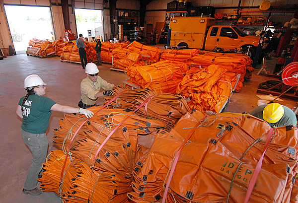 Left to right: Andi Lasselle (CQ), Darian Higgins (cq) and Bob Shannon, all hazardous materials specialists with the Maine Dept. of Environmental Protection's Bangor office, secure oil containment booms to a pallet to ready them for shipment from Maine Thursday morning. The Maine D.E.P. has been readying 13,900 feet of oil containment booms to help with the Gulf of Mexico spill. BANGOR DAILY NEWS PHOTO BY JOHN CLARKE RUSS Left to right: Andi Lasselle (CQ), Darian Higgins (cq) and Bob Shannon, all hazardous materials specialists with the Maine Dept. of Environmental Protection's Bangor office, secure oil containment booms to a pallet to ready them for shipment from Maine Thursday morning. The Maine D.E.P. has been readying 13,900 feet of oil containment booms to help with the Gulf of Mexico spill. BANGOR DAILY NEWS PHOTO BY JOHN CLARKE RUSS