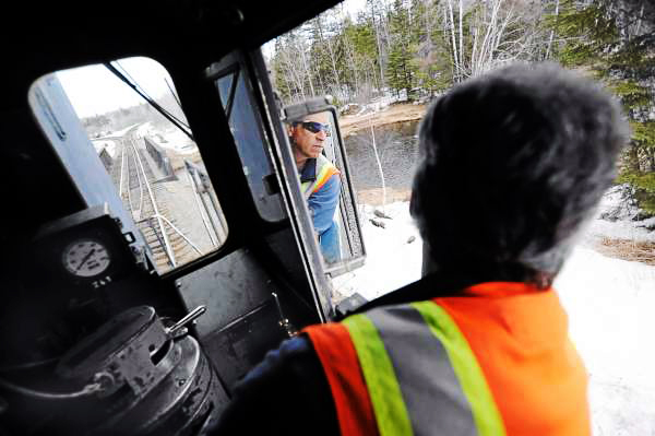 Engineer Rick Cameron of the Montreal, Maine & Atlantic Railway looks in his rearview mirror to check out cars behind him as he reverses Engine 100 at Squapan station recently. Engine 100 was built in 1957. (BANGOR DAILY NEWS PHOTO BY JOHN CLARKE RUSS)
CAPTION
Engineer Rick Cameron of the Montreal, Maine and Atlantic Railway looks at his rearview window to check out the cars behind him as he reverses Engine 100 at the Squapan station in Ashland Thurdsday, March 18, 2010. Engine 100 was built in 1957. Safety concerns and poor maintenance along sections of the MM&A railway in northern Maine sometimes limit the speed of their freight trains to 10 to 15 mph. State officials are seeking a $25 million bond to repair rail in Aroostook, Penobscot and Androscoggin counties. Without such aid railways like MM&A might have to abandon their 241 miles of track which remain crucial to Maine industries. (Bangor Daily News/John Clarke Russ) Engineer Rick Cameron of the Montreal, Maine & Atlantic Railway looks in his rearview mirror to check out cars behind him as he reverses Engine 100 at Squapan station recently. Engine 100 was built in 1957. (BANGOR DAILY NEWS PHOTO BY JOHN CLARKE RUSS)
CAPTION
Engineer Rick Cameron of the Montreal, Maine and Atlantic Railway looks at his rearview window to check out the cars behind him as he reverses Engine 100 at the Squapan station in Ashland Thurdsday, March 18, 2010. Engine 100 was built in 1957. Safety concerns and poor maintenance along sections of the MM&A railway in northern Maine sometimes limit the speed of their freight trains to 10 to 15 mph. State officials are seeking a $25 million bond to repair rail in Aroostook, Penobscot and Androscoggin counties. Without such aid railways like MM&A might have to abandon their 241 miles of track which remain crucial to Maine industries. (Bangor Daily News/John Clarke Russ)