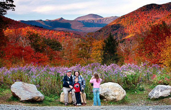 FILE - In this Oct. 6, 2006 file photo, flowers, fall foliage and 6,288-foot Mt. Washington serve as a backdrop for a family picture at Crawford Notch State Park in New Hampshire. The state of New Hampshire is exploring possible commercial sponsorship of its state parks by outdoor outfitter Eastern Mountain Sports, headquartered in New Hampshire. (AP Photo/Robert F. Bukaty, File) FILE - In this Oct. 6, 2006 file photo, flowers, fall foliage and 6,288-foot Mt. Washington serve as a backdrop for a family picture at Crawford Notch State Park in New Hampshire. The state of New Hampshire is exploring possible commercial sponsorship of its state parks by outdoor outfitter Eastern Mountain Sports, headquartered in New Hampshire. (AP Photo/Robert F. Bukaty, File)
