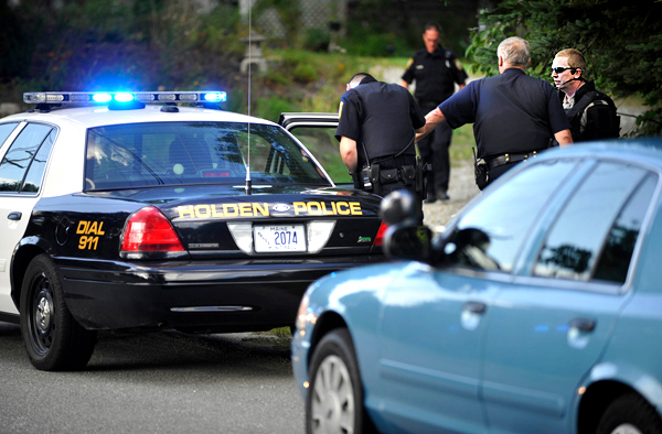 As another officer talked with the suspect in a Holden police car, Chief Troy Morton, far right, of the Penobscot County Sheriff's Dept. Special Response Team conferred with Sgt. Eugene Fizell, second from right, of the Holden Police Dept. after officers resolved a standoff at a residence on Mann Hill Road Saturday afternoon, August 28,2010. With the help of Maine State Police, Penobscot County Special Response Team and the Maine Warden Service, a 25-year-old man was taken into custody by the Holden Police Dept. and transported to Eastern Maine Medical Center for an evaluation. (Bangor Daily News/John Clarke Russ) As another officer talked with the suspect in a Holden police car, Chief Troy Morton, far right, of the Penobscot County Sheriff's Dept. Special Response Team conferred with Sgt. Eugene Fizell, second from right, of the Holden Police Dept. after officers resolved a standoff at a residence on Mann Hill Road Saturday afternoon, August 28,2010. With the help of Maine State Police, Penobscot County Special Response Team and the Maine Warden Service, a 25-year-old man was taken into custody by the Holden Police Dept. and transported to Eastern Maine Medical Center for an evaluation. (Bangor Daily News/John Clarke Russ)