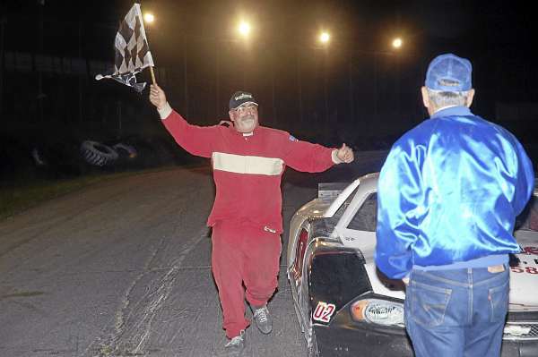 John Phippen running around the car with the checkered flag, his normal vicotry lap that he used to take; he's win a race and get out of his car to run around the cars on the front stretch with the checkered flag instead of driving around the track like drivers normally do. John Phippen running around the car with the checkered flag, his normal vicotry lap that he used to take; he's win a race and get out of his car to run around the cars on the front stretch with the checkered flag instead of driving around the track like drivers normally do.