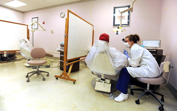 Dental student Heather Lawrence talks with her patient at the University College of Bangor dental health clinic in Bangor on Thursday, September 16, 2010. Dry erase boards have been utilized as walls to offer privacy and help reduce airborne contaminants from traveling to adjacent patient areas. The clinic is spending $3 million to expand and remedy the problems of the aging facility. (Bangor Daily News/Kevin Bennett) Dental student Heather Lawrence talks with her patient at the University College of Bangor dental health clinic in Bangor on Thursday, September 16, 2010. Dry erase boards have been utilized as walls to offer privacy and help reduce airborne contaminants from traveling to adjacent patient areas. The clinic is spending $3 million to expand and remedy the problems of the aging facility. (Bangor Daily News/Kevin Bennett)