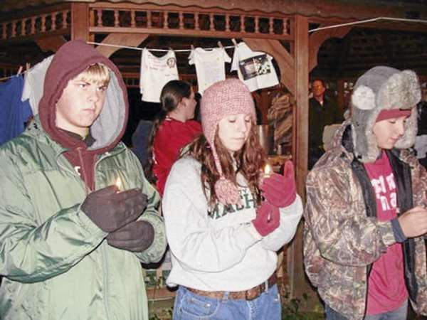 Dexter Regional High School students Erik Robinson (from left), Hayley Gross, and Hunter Belanger hold lighted candles at a domestic violence vigil held Saturday in Wayside Park in Dexter. The students were part of a contingent of students who later spent the night in the park to raise awareness for the homeless. (Bangor Daily News Photo by Diana Bowley) Dexter Regional High School students Erik Robinson (from left), Hayley Gross, and Hunter Belanger hold lighted candles at a domestic violence vigil held Saturday in Wayside Park in Dexter. The students were part of a contingent of students who later spent the night in the park to raise awareness for the homeless. (Bangor Daily News Photo by Diana Bowley)