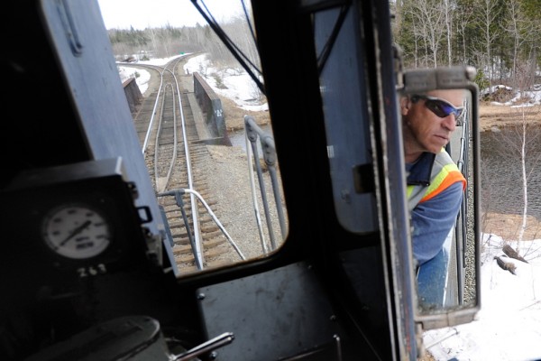 Engineer Rick Cameron of the Montreal, Maine and Atlantic railway looks at his rearview window as he reverses Engine 100 at the Squapan station in Masardis Thurdsday, March 18, 2010. Engine 100 was built in 1957. Safety concerns and poor maintenance along sections of the MM&A railway in northern Maine sometimes limit the speed of their freight trains to 10 to 15 mph. State officials are seeking a $25 million bond to repair rail in Aroostook, Penobscot and Androscoggin counties. Without such aid railways like MM&A might have to abandon their 241 miles of track which remain crucial to Maine industries. (Bangor Daily News/John Clarke Russ) Engineer Rick Cameron of the Montreal, Maine and Atlantic railway looks at his rearview window as he reverses Engine 100 at the Squapan station in Masardis Thurdsday, March 18, 2010. Engine 100 was built in 1957. Safety concerns and poor maintenance along sections of the MM&A railway in northern Maine sometimes limit the speed of their freight trains to 10 to 15 mph. State officials are seeking a $25 million bond to repair rail in Aroostook, Penobscot and Androscoggin counties. Without such aid railways like MM&A might have to abandon their 241 miles of track which remain crucial to Maine industries. (Bangor Daily News/John Clarke Russ)