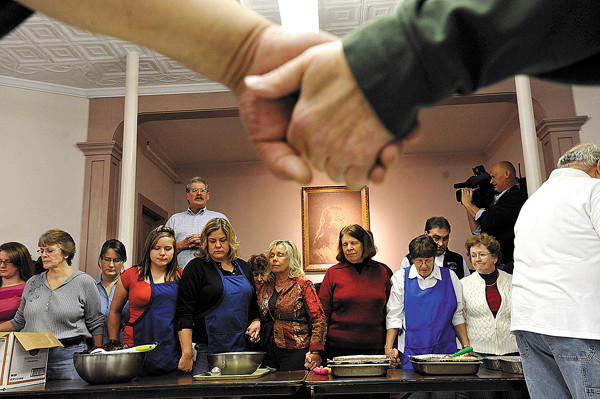 Community members, joining hands, bowed their heads as Manna Minstries executive director Bill Rae, upper left, led a prayer of before the start of Manna Ministries annual free Thanksgiving dinner at Columbia Street Baptist Church in Bangor Thursday morning. Over 100 volunteers and over 100 other area residents attended the event which included approximately 70 pumpkin pies and 30 turkeys-- thanks in large part to area donations. (Bangor Daily News/John Clarke Russ) Community members, joining hands, bowed their heads as Manna Minstries executive director Bill Rae, upper left, led a prayer of before the start of Manna Ministries annual free Thanksgiving dinner at Columbia Street Baptist Church in Bangor Thursday morning. Over 100 volunteers and over 100 other area residents attended the event which included approximately 70 pumpkin pies and 30 turkeys-- thanks in large part to area donations. (Bangor Daily News/John Clarke Russ)