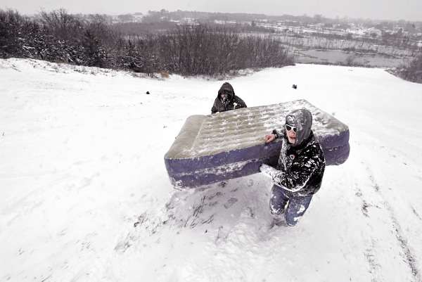 BEDDING DOWN FOR THE WINTER: Husson classmates Isaiah Underwood, left, of Fairfield and Bobby Pizzarelli of Milford, Mass. carry Pizzarelli's air mattress up the slope for another snow run down Watchmaker Hill off Essex St. Monday afternoon, Dec. 6, 2010. They and other classmates assembled there said they were about to return to campus for a dorm hall snowball fight. (Bangor Daily News/ John Clarke Russ) BEDDING DOWN FOR THE WINTER: Husson classmates Isaiah Underwood, left, of Fairfield and Bobby Pizzarelli of Milford, Mass. carry Pizzarelli's air mattress up the slope for another snow run down Watchmaker Hill off Essex St. Monday afternoon, Dec. 6, 2010. They and other classmates assembled there said they were about to return to campus for a dorm hall snowball fight. (Bangor Daily News/ John Clarke Russ)