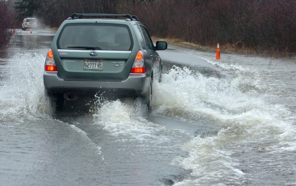 SURF'S UP-- These motorists, like others on the Meadow Road had to navigate a few submerged sections of roadway Monday, Dec. 13, 2010, after heavy rain continued to saturate Maine. This area near the Patterson Road end had about 8 inches of water streaming across. While the road was not closed, some drivers chose an alternative route. Most still used the road, driving down the middle, some fast, some slow. (Bangor Daily News/Scott Haskell) SURF'S UP-- These motorists, like others on the Meadow Road had to navigate a few submerged sections of roadway Monday, Dec. 13, 2010, after heavy rain continued to saturate Maine. This area near the Patterson Road end had about 8 inches of water streaming across. While the road was not closed, some drivers chose an alternative route. Most still used the road, driving down the middle, some fast, some slow. (Bangor Daily News/Scott Haskell)