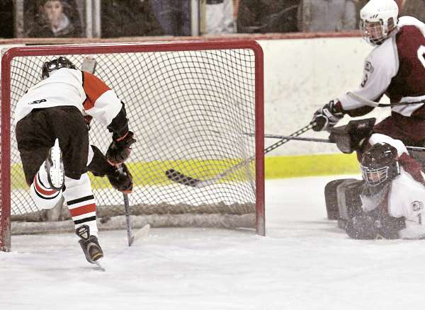 Brewer forward Tyler White shoots the puck into the empty net with Bangor goalie Chris Howatt and defenseman Anthony Capuano (9 ) caught out of position in the final minute of the second period of Wednesday's game in Brewer. The Witches won 9-3. Brewer forward Tyler White shoots the puck into the empty net with Bangor goalie Chris Howatt and defenseman Anthony Capuano (9 ) caught out of position in the final minute of the second period of Wednesday's game in Brewer. The Witches won 9-3.