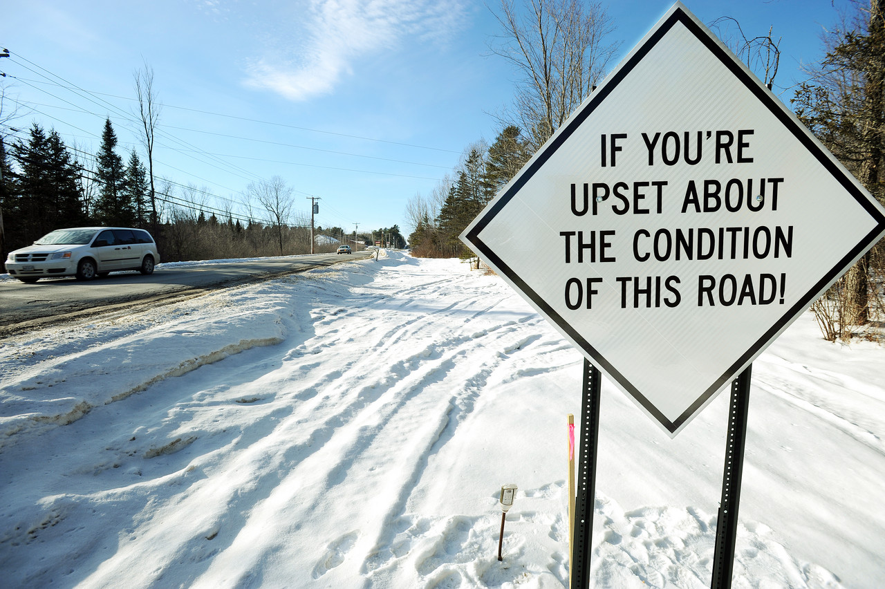 Traffic passes along Route 2 in Carmel on Thursday, January 6, 2011. Carmel Town Manager Tom Richmond authorized the posting of four new signs that encourage motorist to call Governor LePage's office if they want to complain about the miserable road conditions along the main road that runs thorough the town. (BDN Photo by Kevin Bennett) Traffic passes along Route 2 in Carmel on Thursday, January 6, 2011. Carmel Town Manager Tom Richmond authorized the posting of four new signs that encourage motorist to call Governor LePage's office if they want to complain about the miserable road conditions along the main road that runs thorough the town. (BDN Photo by Kevin Bennett)