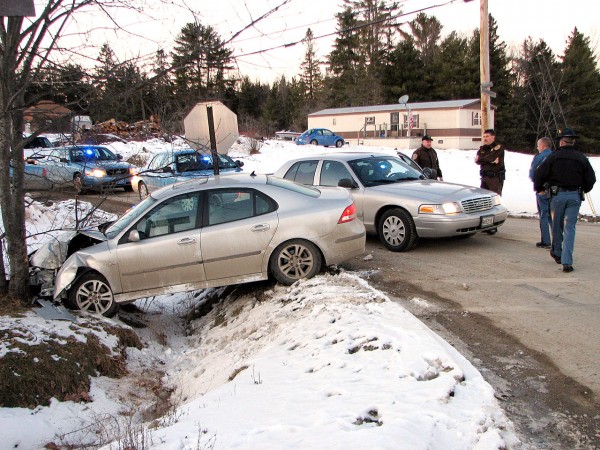 Police confer with each other Monday afternoon after trying to stop a reportedly stolen car before it crashed into a tree at the intersection of Route 182 and Route 200 in Franklin. Following a high-speed chase, two men were arrested, one at the accident scene and another less than an hour later in Ellsworth after he tried to get away allegedly by stealing a second car nearby moments after the Franklin crash. Police believe the car in the photo may have been involved in a Dec. 30 armed robbery attempt in Ellsworth. (BDN photo by Bill Trotter) Police confer with each other Monday afternoon after trying to stop a reportedly stolen car before it crashed into a tree at the intersection of Route 182 and Route 200 in Franklin. Following a high-speed chase, two men were arrested, one at the accident scene and another less than an hour later in Ellsworth after he tried to get away allegedly by stealing a second car nearby moments after the Franklin crash. Police believe the car in the photo may have been involved in a Dec. 30 armed robbery attempt in Ellsworth. (BDN photo by Bill Trotter)