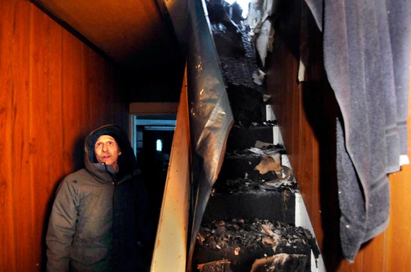 On Wednesday Mike Russell looked over fire damage to the rental home he was living in before a stove and chimney fire gutted a major portion of it Tuesday evening. Some of the charred remains of the second floor had spilled into the stairwell (on right). So far, he said three of his neighbors on Park Street in Kingman have offered to put him up until he can find housing. (BDN photo by John Clarke Russ) On Wednesday Mike Russell looked over fire damage to the rental home he was living in before a stove and chimney fire gutted a major portion of it Tuesday evening. Some of the charred remains of the second floor had spilled into the stairwell (on right). So far, he said three of his neighbors on Park Street in Kingman have offered to put him up until he can find housing. (BDN photo by John Clarke Russ)