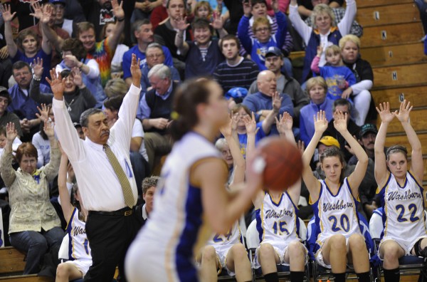 Washburn coach Mike Carlos and his players hold up their hands in support while a player shoots a free throw in their Eastern Maine Class D final against Deer Isle-Stonington Saturday. Washburn coach Mike Carlos and his players hold up their hands in support while a player shoots a free throw in their Eastern Maine Class D final against Deer Isle-Stonington Saturday.