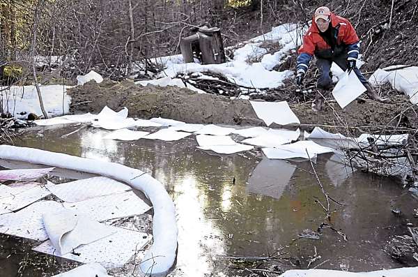Standing on a freshly-made dirt dam several hundred yards downstream from the spill site, William Smith, a foreman with Clean Harbor Environmental Services, throws down sorbent pads to help soak up some of the approximately 1000 gallons of oil that spilled from a oil tank truck off the Tibbetstown Rd. in Columbia Falls. The Maine Dept. of Environmental Protection, the Maine Dept. of Marine Resources and Clean Harbor Environmental Services quickly responded Tuesday. Standing on a freshly-made dirt dam several hundred yards downstream from the spill site, William Smith, a foreman with Clean Harbor Environmental Services, throws down sorbent pads to help soak up some of the approximately 1000 gallons of oil that spilled from a oil tank truck off the Tibbetstown Rd. in Columbia Falls. The Maine Dept. of Environmental Protection, the Maine Dept. of Marine Resources and Clean Harbor Environmental Services quickly responded Tuesday.