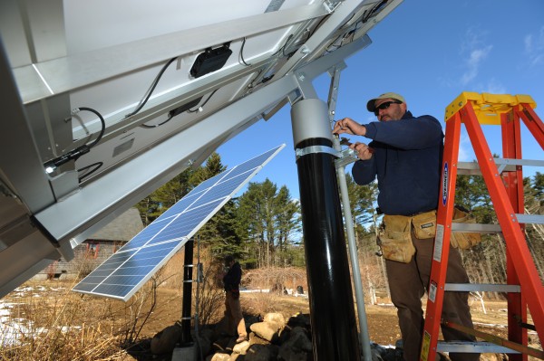 ReVision Energy employee Brian Bryne (right) and Eric Herz (left) finish up wiring on a pair of solar collectors on a Camden home on Wednesday, April 6, 2011. ReVision Energy employee Brian Bryne (right) and Eric Herz (left) finish up wiring on a pair of solar collectors on a Camden home on Wednesday, April 6, 2011.