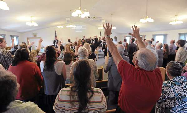 Jimmy Holmes (right) raises both hands heavenward on Sunday as he joins other Calvary Apostolic Church members on the first service being held at the Winterport Baptist Church after Wilbur "Wes" Strout ingnited a fire at the Calvary Apostolic Church on Route 1A in Winterport on Thursday, May 5, 2011, that killed him and destroyed the building. Jimmy Holmes (right) raises both hands heavenward on Sunday as he joins other Calvary Apostolic Church members on the first service being held at the Winterport Baptist Church after Wilbur "Wes" Strout ingnited a fire at the Calvary Apostolic Church on Route 1A in Winterport on Thursday, May 5, 2011, that killed him and destroyed the building.