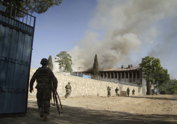 Afghan soldiers run to surround the police traffic department building, after it was attacked by insurgents, in Khost, eastern of Afghanistan on Sunday, May 22, 2011. Gunmen wearing police uniforms and suicide vests stormed a government building in eastern Afghanistan early Sunday, starting a running shootout with Afghan security forces who surrounded the compound, officials said. At least five people were killed in ongoing fight it as a fire raged through the structure. Afghan soldiers run to surround the police traffic department building, after it was attacked by insurgents, in Khost, eastern of Afghanistan on Sunday, May 22, 2011. Gunmen wearing police uniforms and suicide vests stormed a government building in eastern Afghanistan early Sunday, starting a running shootout with Afghan security forces who surrounded the compound, officials said. At least five people were killed in ongoing fight it as a fire raged through the structure.