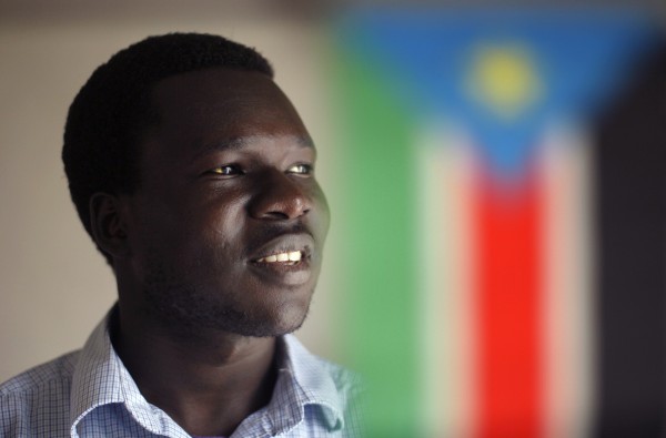 Aruna Kenyi poses behind a Sudanese flag at his home in Portland on Thursday, May 19, 2011. It has been 16 years since Kenyi fled his small remote village in terror when it was attacked and torched by the militia during the Sudanese Civil War. "Between Two Rivers," Kenyi's recently published memoir, is the story of his journey from East Africa to Southern Maine. Aruna Kenyi poses behind a Sudanese flag at his home in Portland on Thursday, May 19, 2011. It has been 16 years since Kenyi fled his small remote village in terror when it was attacked and torched by the militia during the Sudanese Civil War. "Between Two Rivers," Kenyi's recently published memoir, is the story of his journey from East Africa to Southern Maine.