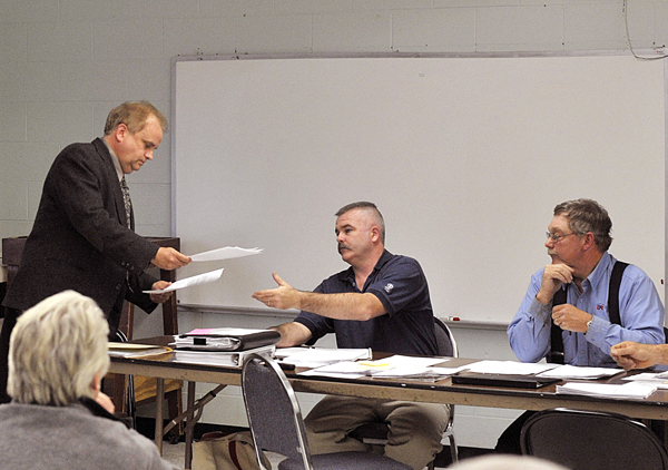 Town manager Rick Briggs hands in his resignation to selectman Mike Burns at a public meeting held Thursday night at the former Newburgh Elementary school, now the town office. Town manager Rick Briggs hands in his resignation to selectman Mike Burns at a public meeting held Thursday night at the former Newburgh Elementary school, now the town office.