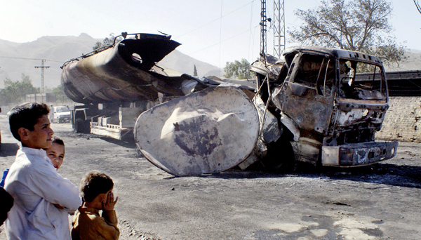 Pakistani youngsters stand next to a burnt NATO oil tanker caused by alleged militants attacked in Landi Kotal near Afghan border in Pakistan on Saturday. A tanker carrying oil for NATO forces in Afghanistan exploded Saturday in northwestern Pakistan as people tried to siphon off some of its fuel, and 15 were killed, an official said. Pakistani youngsters stand next to a burnt NATO oil tanker caused by alleged militants attacked in Landi Kotal near Afghan border in Pakistan on Saturday. A tanker carrying oil for NATO forces in Afghanistan exploded Saturday in northwestern Pakistan as people tried to siphon off some of its fuel, and 15 were killed, an official said.