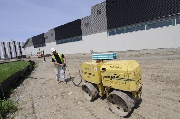 Ron Richardson of Sebec, an employee of the Sargent Corporation, uses a compactor to grade the outside of the soon-to-be-completed Advanced Nanocomposites in Renewable Energy Laboratory at the University of Maine in Orono on Friday, May 13, 2011. Once completed later this summer, the laboratory will boast the longest wind testing floor in the U.S. The large black panels on the south side of the building (seen in the background of the photo) are air solar collectors to help heat the interior of the building during the cold months. Ron Richardson of Sebec, an employee of the Sargent Corporation, uses a compactor to grade the outside of the soon-to-be-completed Advanced Nanocomposites in Renewable Energy Laboratory at the University of Maine in Orono on Friday, May 13, 2011. Once completed later this summer, the laboratory will boast the longest wind testing floor in the U.S. The large black panels on the south side of the building (seen in the background of the photo) are air solar collectors to help heat the interior of the building during the cold months.