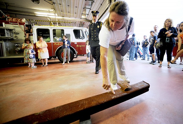 Alfreda Fournier of Auburn reaches down to touch a piece of twisted steel from the World Trade Center that was delivered to Auburn's Central Fire Station on Thursday evening. "I think it brings back the possibility of evil in this world and reminds us to respect our military," Fournier said, "because as we're living here safe at home, they are fighting for our freedoms." For a video of the delivery, please visit www.sunjournal.com. Alfreda Fournier of Auburn reaches down to touch a piece of twisted steel from the World Trade Center that was delivered to Auburn's Central Fire Station on Thursday evening. "I think it brings back the possibility of evil in this world and reminds us to respect our military," Fournier said, "because as we're living here safe at home, they are fighting for our freedoms." For a video of the delivery, please visit www.sunjournal.com.