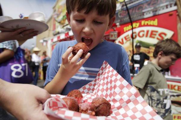 Jackson Perry, of San Diego, takes a bite of a fried Kool-Aid ball at the San Diego County Fair on Tuesday, June 21, 2011, in Del Mar, Calif. The crispy balls with their red-hot insides are a big seller at the fair this year. Jackson Perry, of San Diego, takes a bite of a fried Kool-Aid ball at the San Diego County Fair on Tuesday, June 21, 2011, in Del Mar, Calif. The crispy balls with their red-hot insides are a big seller at the fair this year.