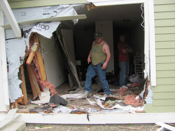 Joseph Sanborn steps over wreckage in his living room on Friday after a car crashed through the wall at 104 Somerset Ave. Joseph Sanborn steps over wreckage in his living room on Friday after a car crashed through the wall at 104 Somerset Ave.