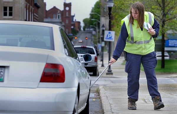 Bangor Police parking enforcement officer Marcia McGrath chalks tires on Exchange Street while making her rounds in downtown Bangor in May. City councilors voted Wednesday to move one step forward with a proposal to turn over downtown parking management and enforcement to a private company, which would possibly put McGrath and other parking enforcement officers out of a job. Bangor Police parking enforcement officer Marcia McGrath chalks tires on Exchange Street while making her rounds in downtown Bangor in May. City councilors voted Wednesday to move one step forward with a proposal to turn over downtown parking management and enforcement to a private company, which would possibly put McGrath and other parking enforcement officers out of a job.