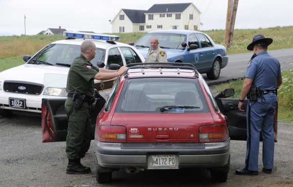 Warden Josh Tibbetts (from left), Penobscot Sheriffs Deputy James Kennedy and Maine State Trooper Douglas Franklin compared notes as they looked over a red Suburu driven by Paul Flynn (not pictured), 50, of Albion whom they stopped and arrested on the corner of Pine Tree Road and Fuller Road. in Levant on Tuesday morning, July 26, 2011. Flynn, who was wanted by area police, tried to buy liquor at the Levant Corner Store just minutes earlier. Warden Josh Tibbetts (from left), Penobscot Sheriffs Deputy James Kennedy and Maine State Trooper Douglas Franklin compared notes as they looked over a red Suburu driven by Paul Flynn (not pictured), 50, of Albion whom they stopped and arrested on the corner of Pine Tree Road and Fuller Road. in Levant on Tuesday morning, July 26, 2011. Flynn, who was wanted by area police, tried to buy liquor at the Levant Corner Store just minutes earlier.