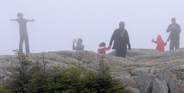 Ali Abdujabrar (second from left) of Massachusetts takes a photo of friend Aadil Ahmed (far left) of Connecticut as they join other friends and family atop Cadillac Mountain in Acadia National park on Saturday afternoon. They joined thousands of other out-of-state tourists visiting Bar Harbor and other Maine spots over Memorial Day weekend. This was their first visit to Maine, they said. Ali Abdujabrar (second from left) of Massachusetts takes a photo of friend Aadil Ahmed (far left) of Connecticut as they join other friends and family atop Cadillac Mountain in Acadia National park on Saturday afternoon. They joined thousands of other out-of-state tourists visiting Bar Harbor and other Maine spots over Memorial Day weekend. This was their first visit to Maine, they said.