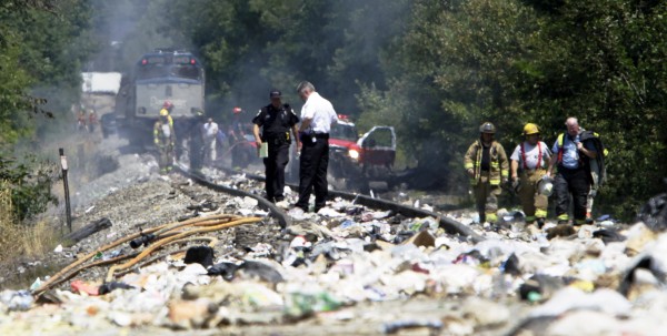 Officials survey the area around an Amtrak train that collided into a tractor-trailer Monday, July 11, 2011, in North Berwick, Maine. Both were set on fire an official said and the truck driver was killed. Officials survey the area around an Amtrak train that collided into a tractor-trailer Monday, July 11, 2011, in North Berwick, Maine. Both were set on fire an official said and the truck driver was killed.