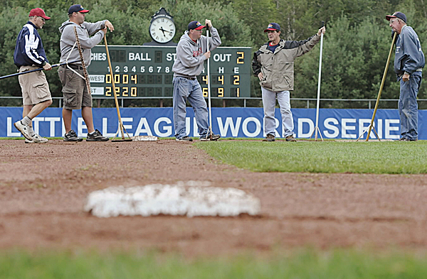 The field crew takes a very brief yet well-earned break late Tuesday afternoon after raking the field at Mansfield Stadium during the rain delays for the Senior League World Series games. By late afternoon the crew had mowed the field and spread more than three tons of Turface, a clay-based soil conditioner, to accelerate the drying of the pitcher's mound, base paths and periphery. From left are tournament trainer Lester Cowan, David Utterback, Barrett Dionne, Dennis Libbey and Jim Owens. The field crew takes a very brief yet well-earned break late Tuesday afternoon after raking the field at Mansfield Stadium during the rain delays for the Senior League World Series games. By late afternoon the crew had mowed the field and spread more than three tons of Turface, a clay-based soil conditioner, to accelerate the drying of the pitcher's mound, base paths and periphery. From left are tournament trainer Lester Cowan, David Utterback, Barrett Dionne, Dennis Libbey and Jim Owens.