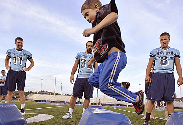 Trey Lyon of Bangor jumps through an obstacle course Wednesday during a Meet the Black Bears event at the University of Maine in Orono. Black Bear football players John Ebeling (left), Troy Eastman (center) and Warren Smith look on. Trey Lyon of Bangor jumps through an obstacle course Wednesday during a Meet the Black Bears event at the University of Maine in Orono. Black Bear football players John Ebeling (left), Troy Eastman (center) and Warren Smith look on.