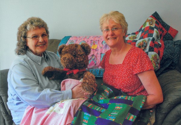 Eda Stoll (right) and Linda Applebee with quilts and teddy bear, which are included in the "Bags of Love" given to children who are removed from their homes by social service agencies for their own protection. Eda Stoll (right) and Linda Applebee with quilts and teddy bear, which are included in the "Bags of Love" given to children who are removed from their homes by social service agencies for their own protection.