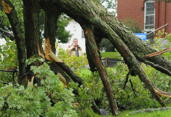 A man smokes a cigarette while inspecting a tree that was topled by high winds from hurricane Irene along Union Street in Bangor on Sunday, August 28, 2011. A man smokes a cigarette while inspecting a tree that was topled by high winds from hurricane Irene along Union Street in Bangor on Sunday, August 28, 2011.
