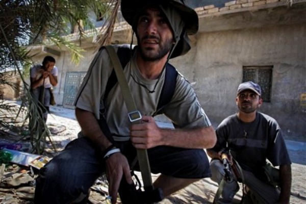 Rebel fighters look towards the enemy as they hear the sound of bombardments in the village of Mayah, some 30 kilometers west from Tripoli, LIbya, Sunday, Aug. 21. Rebel fighters look towards the enemy as they hear the sound of bombardments in the village of Mayah, some 30 kilometers west from Tripoli, LIbya, Sunday, Aug. 21.