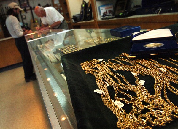 Amidst displays of gold jewelry, Orlando Frati Sr. (right) helps a customer on Monday, Aug. 15, 2011, at his business, Frati's Pawn Shop in Bangor. "We've had a lot of people looking to buy and sell because the price is up so high," said Frati of the recent soaring gold prices. Amidst displays of gold jewelry, Orlando Frati Sr. (right) helps a customer on Monday, Aug. 15, 2011, at his business, Frati's Pawn Shop in Bangor. "We've had a lot of people looking to buy and sell because the price is up so high," said Frati of the recent soaring gold prices.