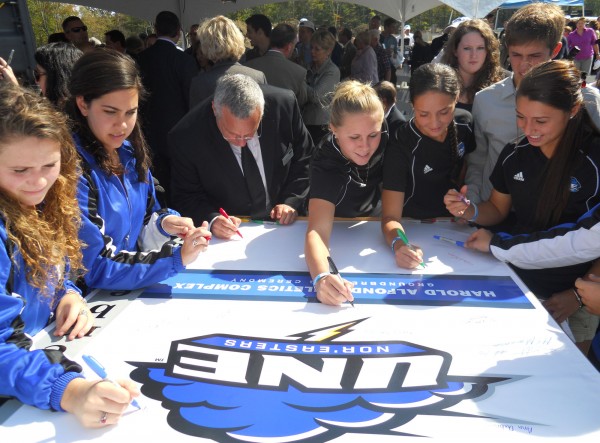 Student athletes and dignitaries in attendance at a Monday ceremony celebrating University of New England's new sports complex sign a banner commemorating the event. Student athletes and dignitaries in attendance at a Monday ceremony celebrating University of New England's new sports complex sign a banner commemorating the event.