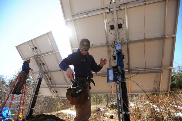 ReVision Energy employees Brian Bryne (left) and Eric Hertz finish the wiring on a pair of solar collectors at a Camden home in April. ReVision Energy employees Brian Bryne (left) and Eric Hertz finish the wiring on a pair of solar collectors at a Camden home in April.