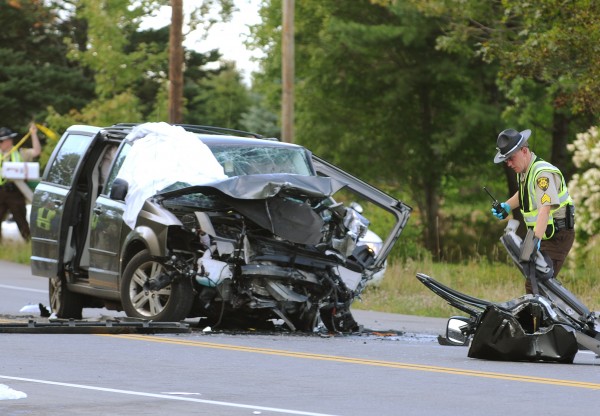 Penobscot Sheriff Deputy William Birch pulls debris from the ditch and piles it next to one of two vans that were involved in a head-on collision on Route 9 in Eddington on Thursday. Penobscot Sheriff Deputy William Birch pulls debris from the ditch and piles it next to one of two vans that were involved in a head-on collision on Route 9 in Eddington on Thursday.